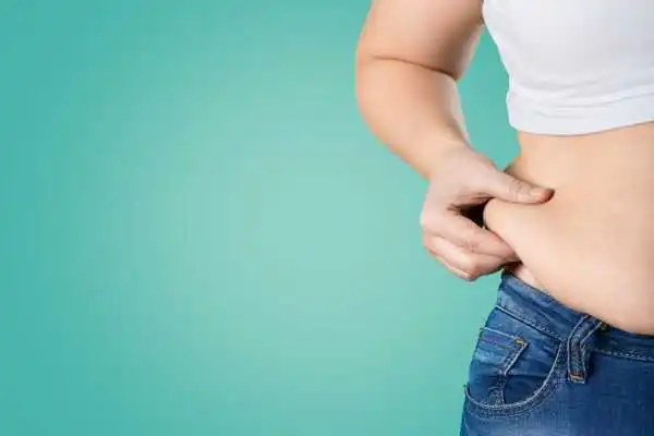 Image of woman pinching her love handles to show weight gain Bury