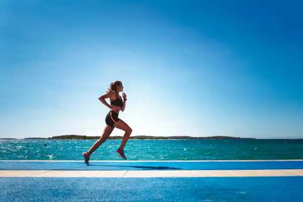 Woman running showing strong leg muscle Bury